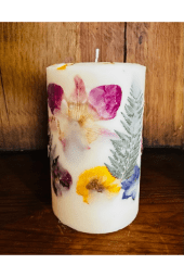 A candle with flowers and leaves on it.