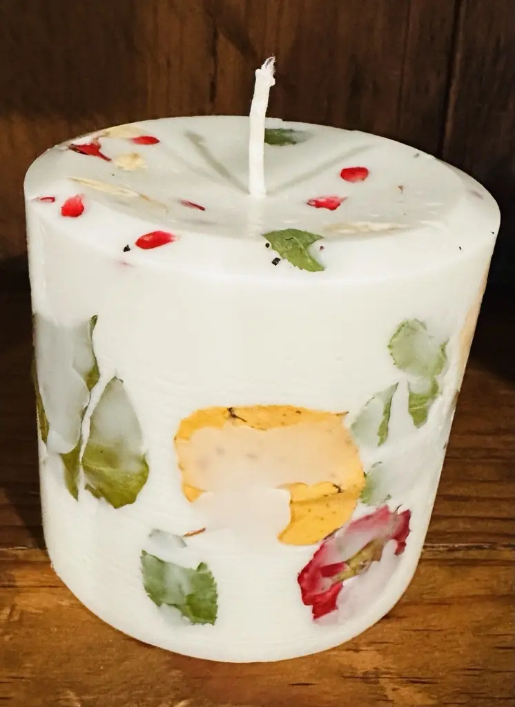 A Frasier Fir Pillar (4x4) candle with flowers on it.